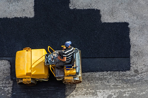 Contractor filling cracks in asphalt pavement