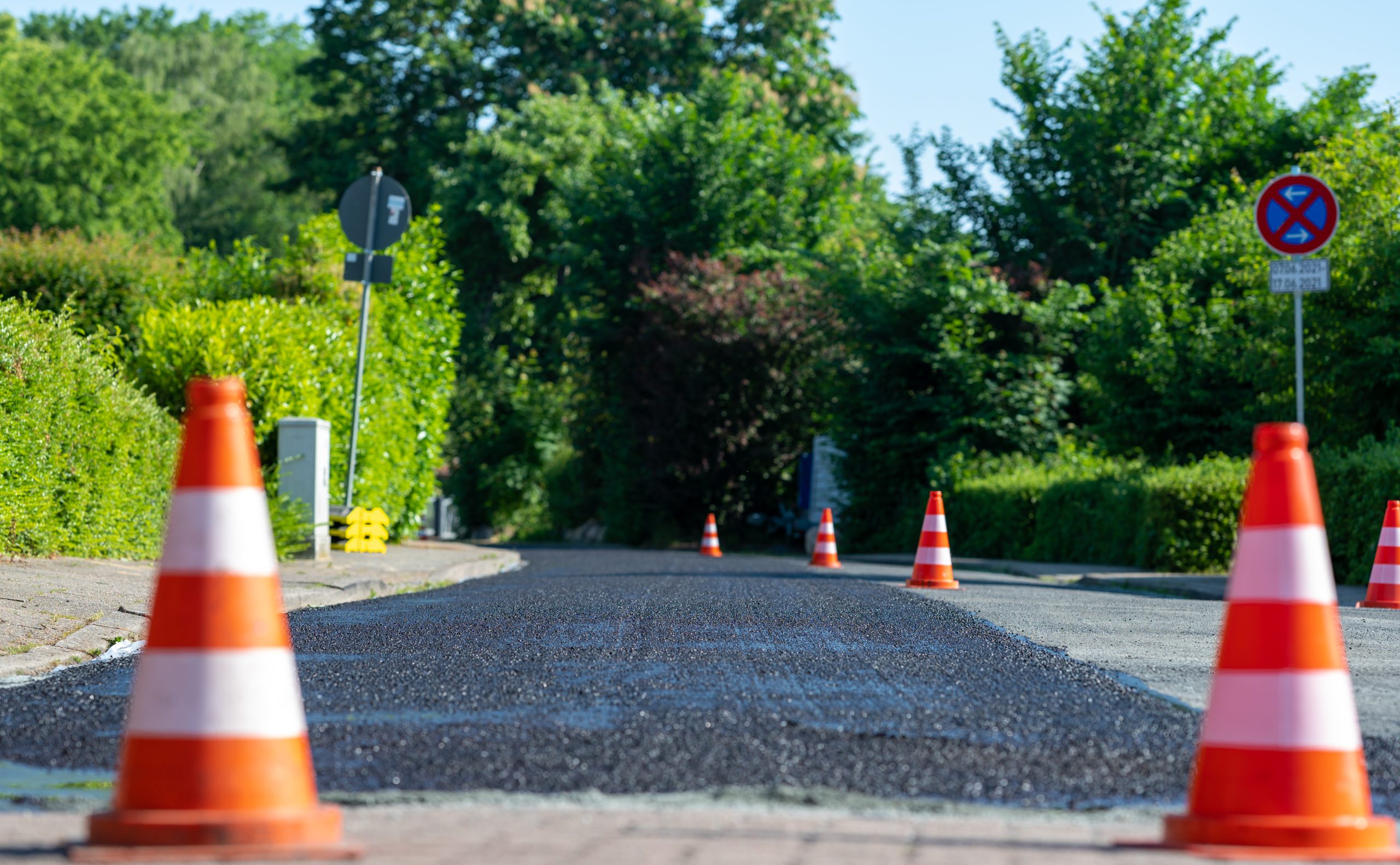 Construction cones marking part of road with a layer of fresh asphalt. S&S Paving LLC